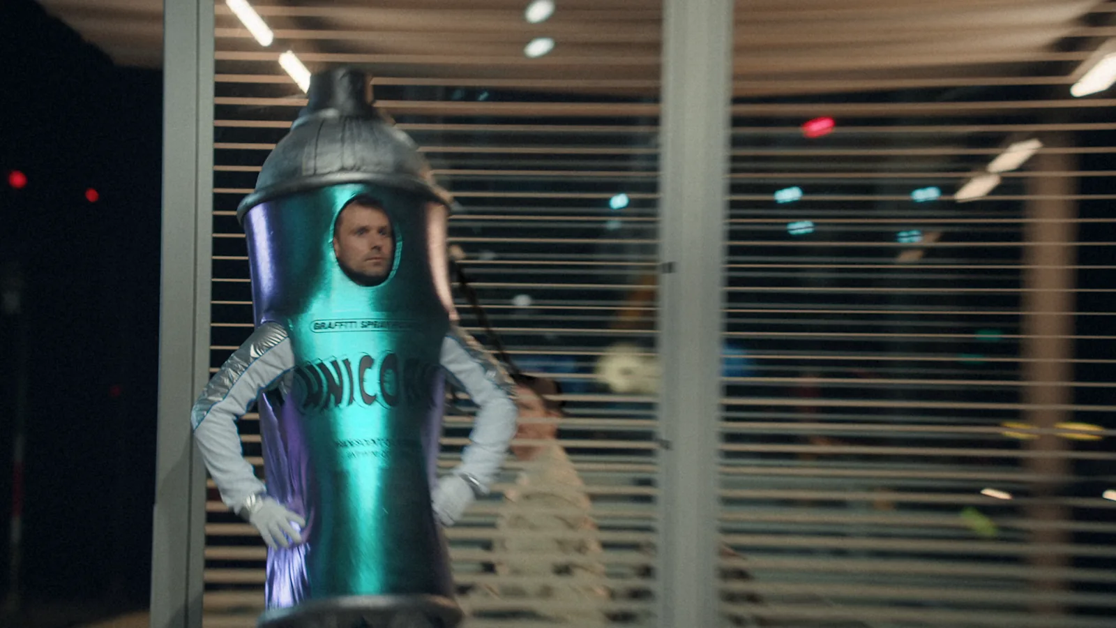 A person dressed as a spray can at a railway station.
